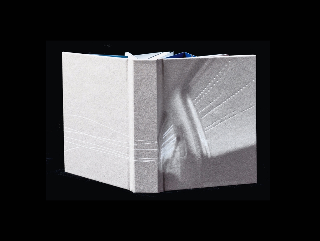 Closed artist book on a black background